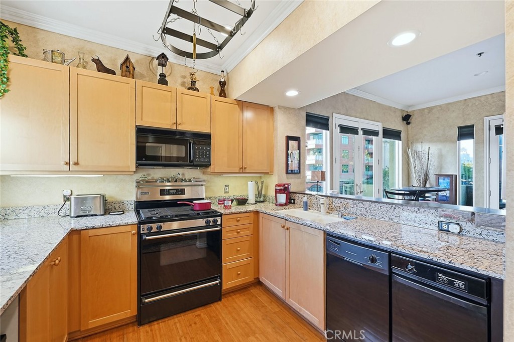 80 North Raymond Avenue, Unit 212 Pasadena, CA 91103 - Photo 11 of 24 a kitchen with stainless steel appliances granite countertop a sink a stove top oven a counter space and cabinets