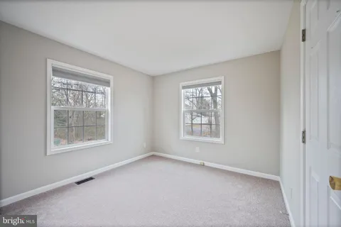 an empty room with ceiling fan and window