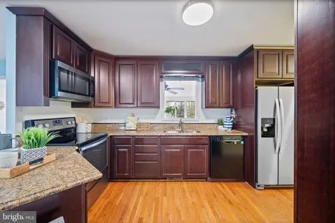 a kitchen with stainless steel appliances granite countertop a refrigerator a stove top oven a sink and dishwasher
