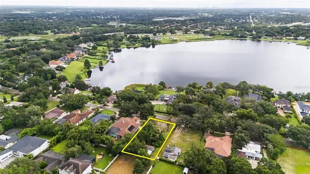 an aerial view of lake residential house with outdoor space and trees around