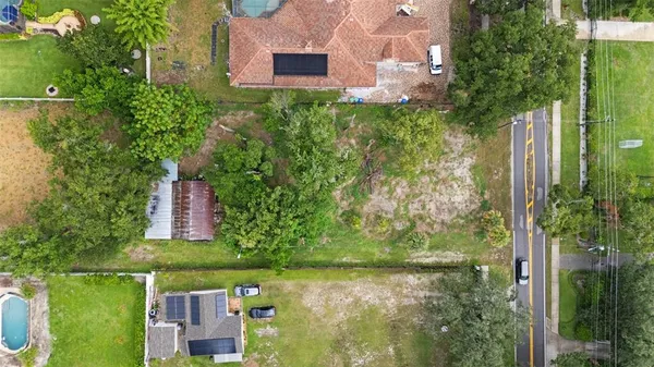 a aerial view of a house with a yard and large trees