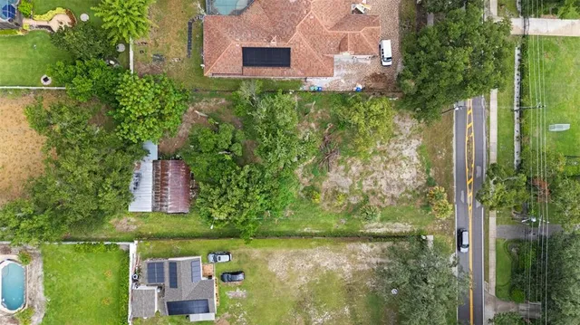 a aerial view of a house with a yard and large trees
