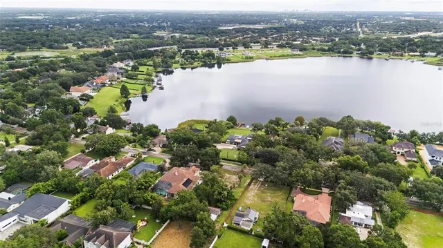 an aerial view of lake residential house with outdoor space and trees around