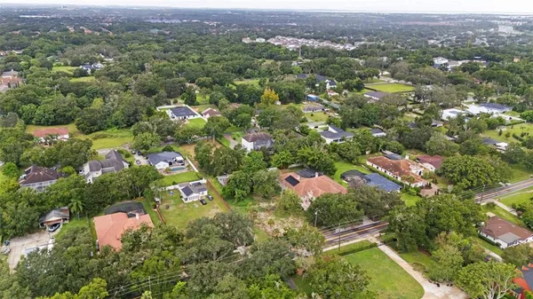 an aerial view of residential house with parking and yard