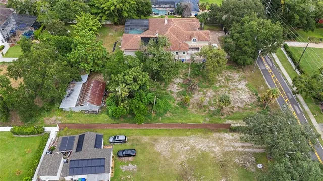 an aerial view of residential house with outdoor space and trees all around