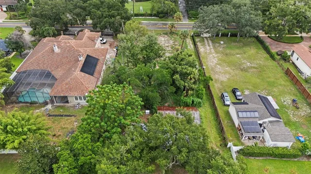 an aerial view of residential houses with outdoor space and trees all around