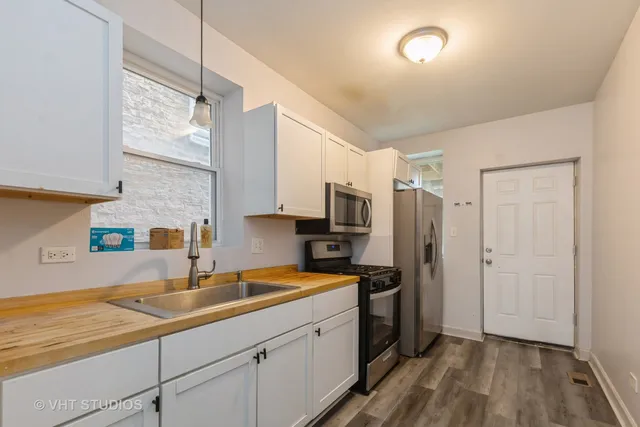 a kitchen with a sink a refrigerator and cabinets