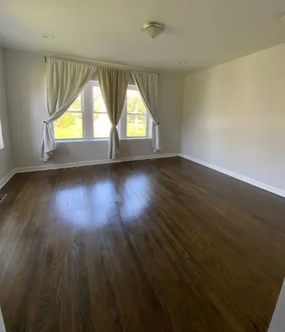a view of an empty room and wooden floor