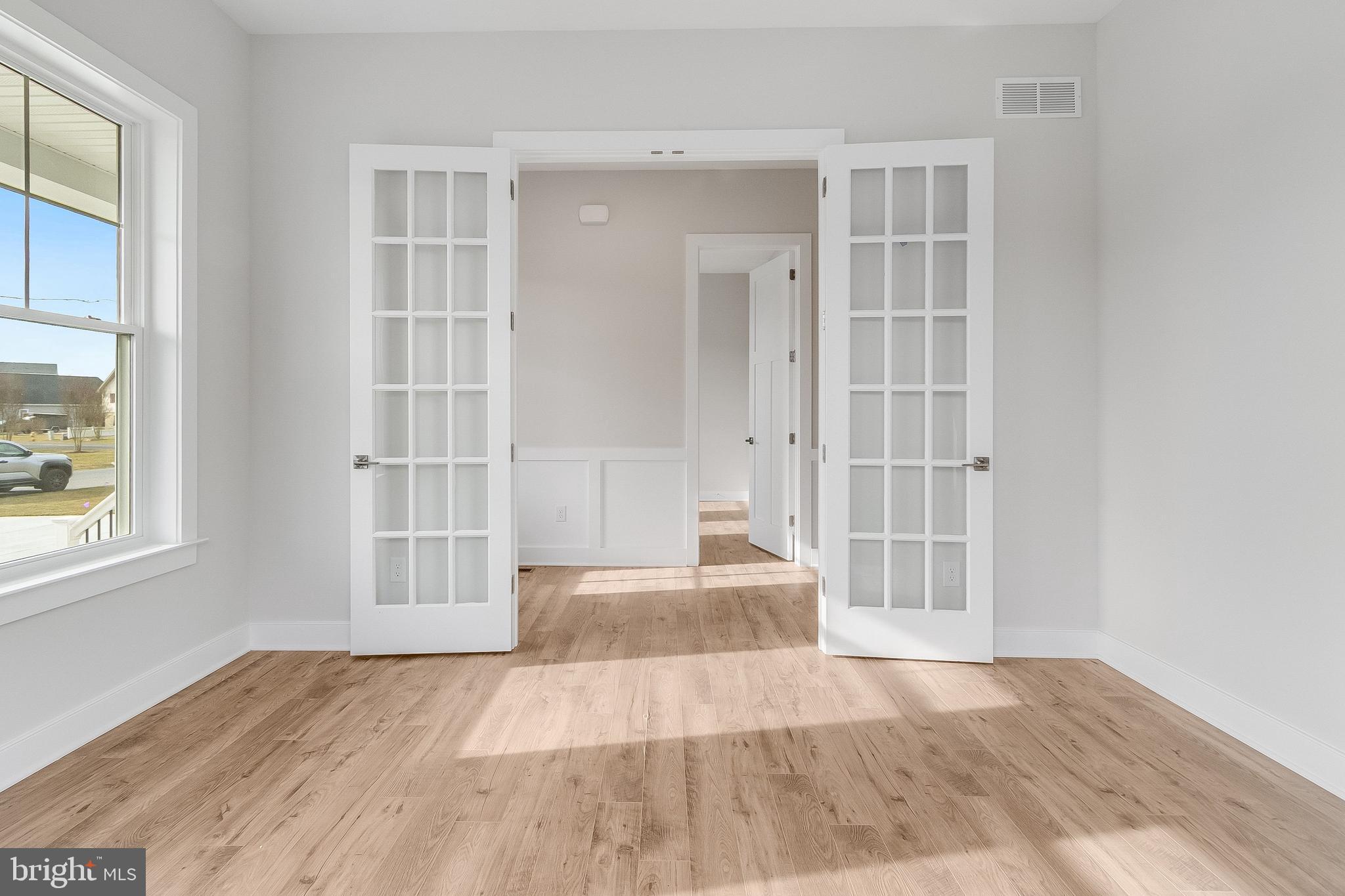37828 Cedar Road Selbyville, DE 19975 - Photo 11 of 109 an empty room with wooden floor and windows
