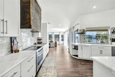 a large kitchen with stainless steel appliances granite countertop a lot of counter space and wooden floors