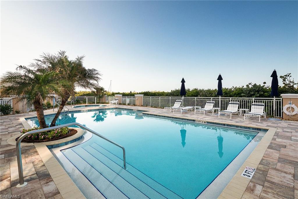 435 Dockside Drive, Unit B703 Naples, FL 34110 - Photo 29 of 38 a view of a swimming pool with outdoor seating and plants
