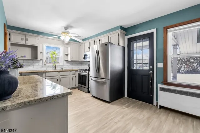 a kitchen with stainless steel appliances granite countertop a refrigerator a sink a stove and oven