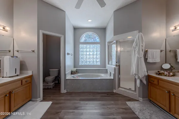 a spacious bathroom with a tub sink and mirror