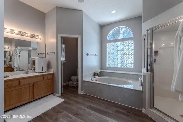 a spacious bathroom with a tub sink and mirror