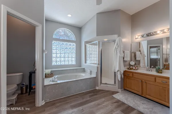 a spacious bathroom with a tub sink and mirror