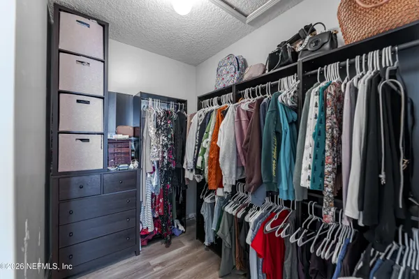 a view of walk in closet with clothes