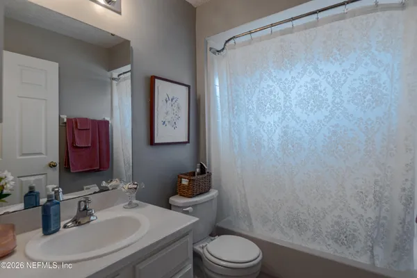a bathroom with a sink a toilet and shower curtain