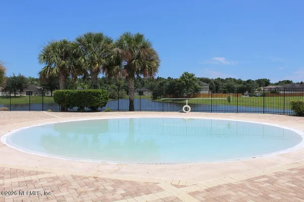 a view of outdoor space with swimming pool and trees in the background