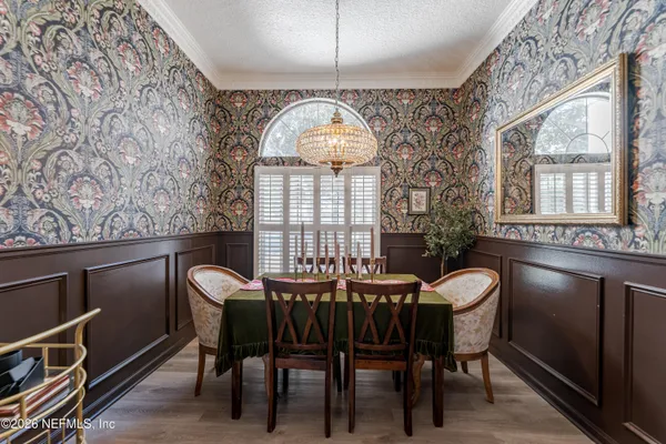 a view of a dining room with furniture and a chandelier
