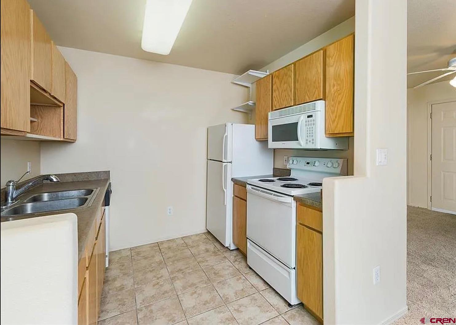 1100 Goeglein Gulch Road, Unit 167 Durango, CO 81301 - Photo 10 of 20 a kitchen with a stove a microwave and a refrigerator