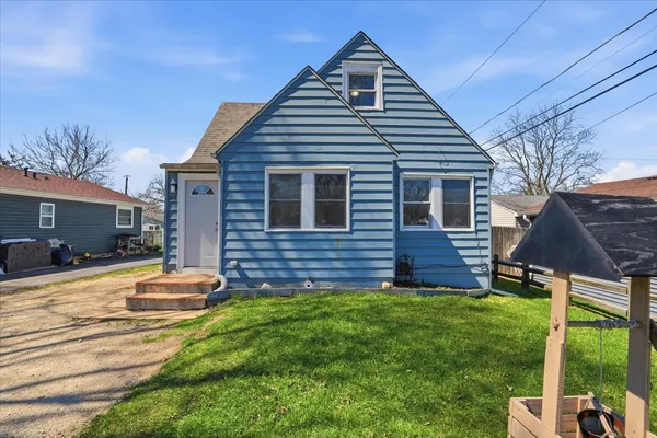 a backyard of a house with table and chairs