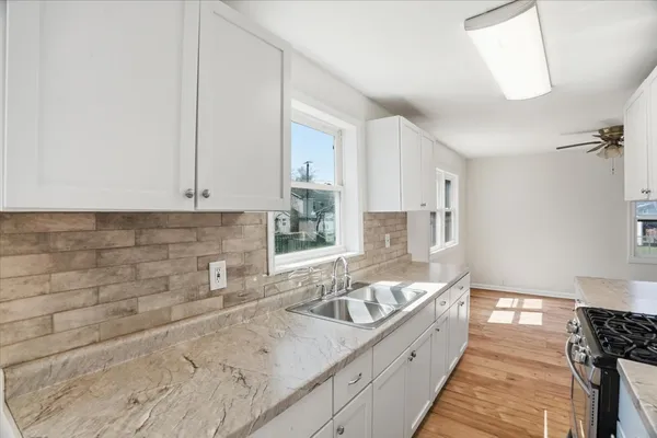 a large kitchen with a sink and cabinets