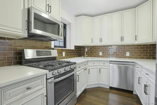 a kitchen with cabinets appliances and a wooden floor