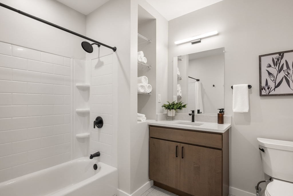 22 Elm Street, Unit 302 Worcester, MA 01608 - Photo 16 of 18 a bathroom with a sink mirror toilet and bathtub