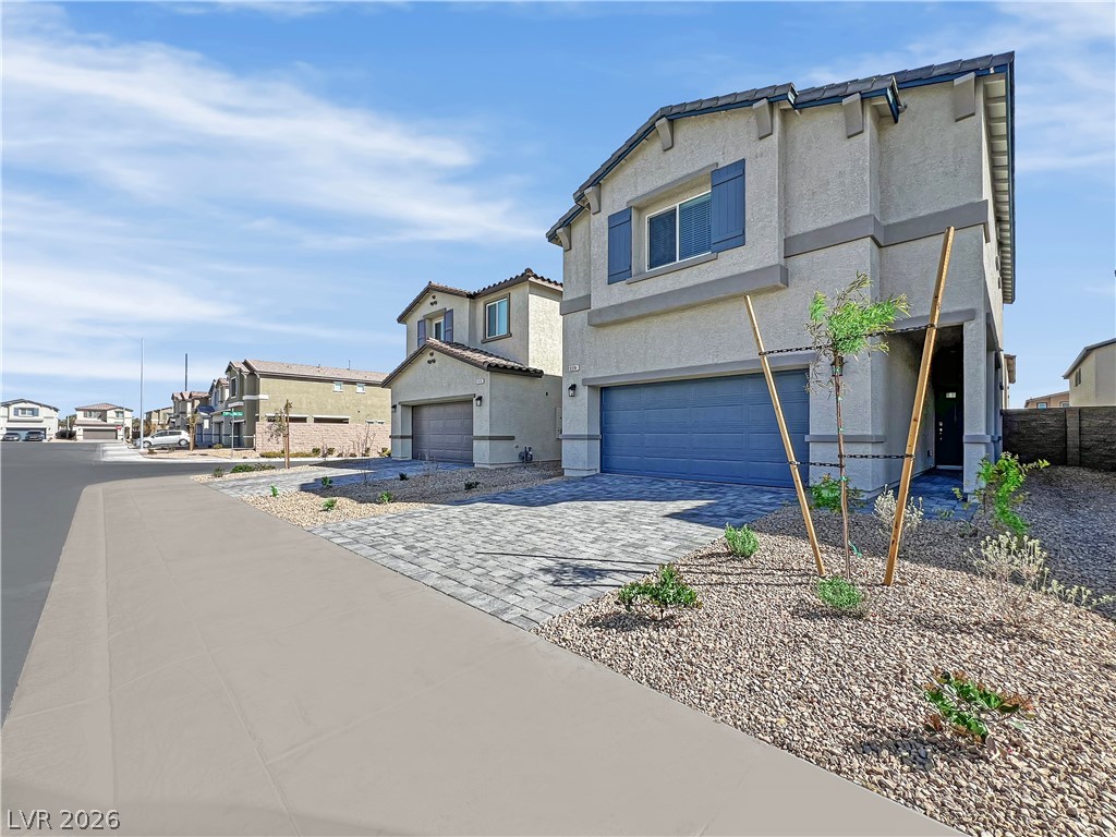 9984 Indigo Cliffs Street Las Vegas, NV 89141 - Photo 1 of 31 View of front facade featuring stucco siding, a garage, a tiled roof, decorative driveway, and a residential view