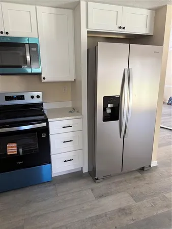 a kitchen with white cabinets and stainless steel appliances