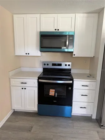 a kitchen with stainless steel appliances a stove a microwave and cabinets