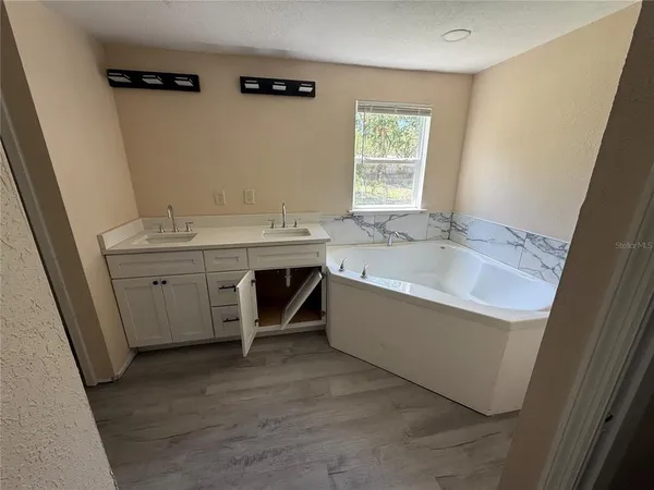 a bathroom with a tub sink and mirror