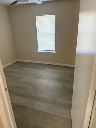 a view of a small space with wooden floor and a window