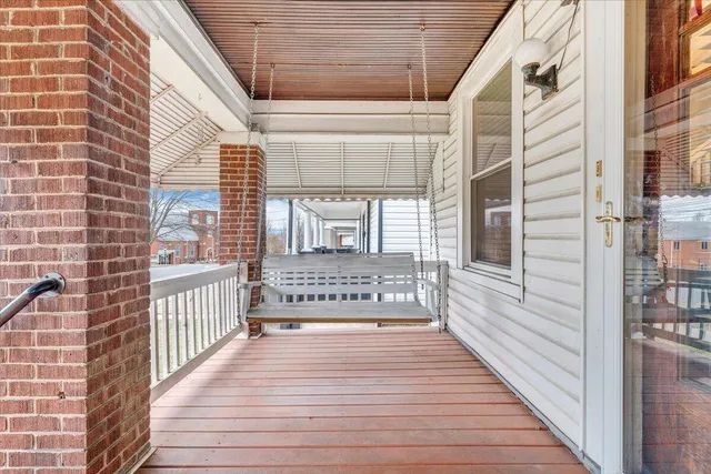 a view of a porch with wooden floor and a floor to ceiling window