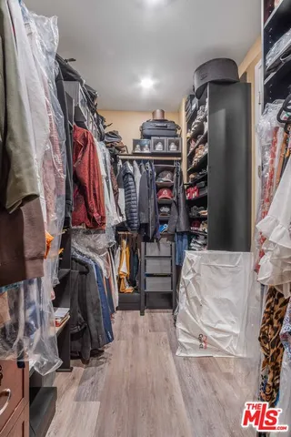 a view of walk in closet with clothes