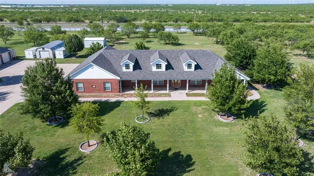 an aerial view of residential houses with outdoor space and trees