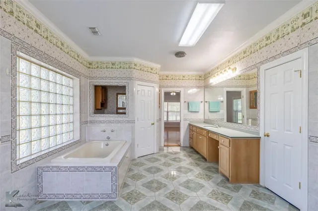 a bathroom with a sink a bathtub and a double vanity sink