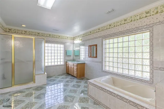 a bathroom with a tub a sink a window and a shower