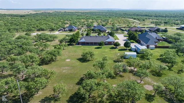an aerial view of residential house with outdoor space and trees all around