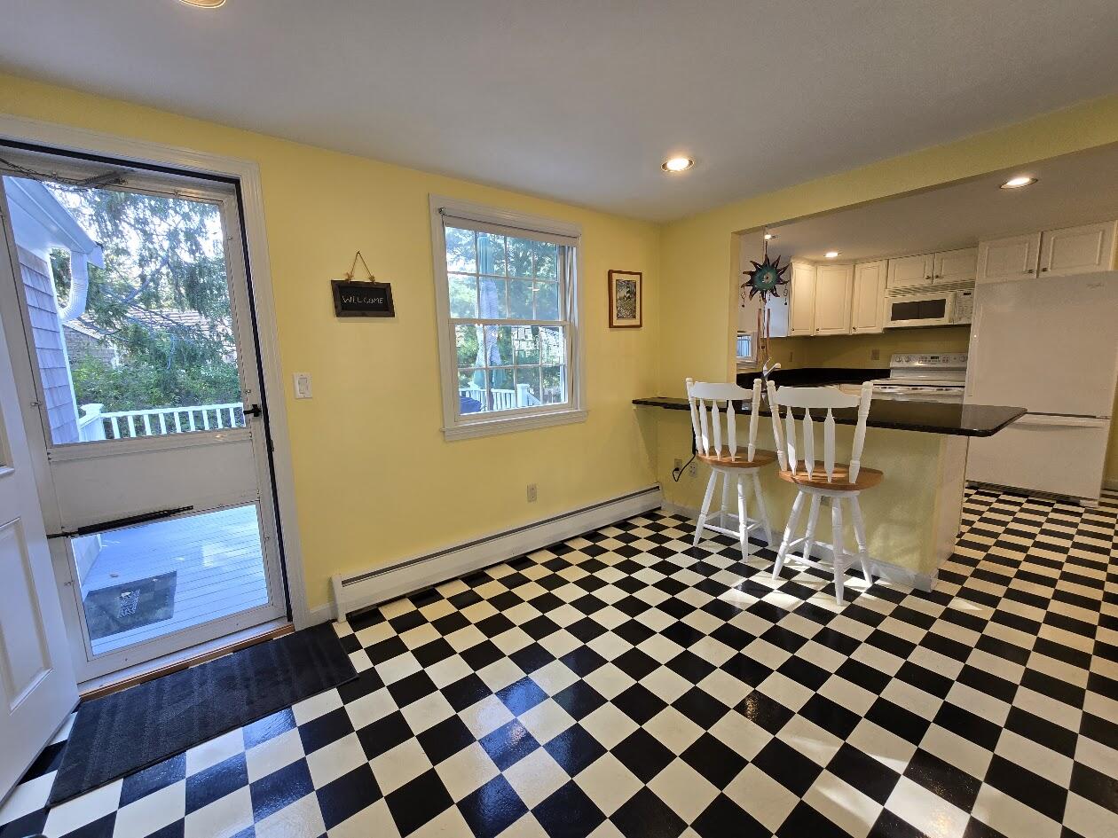 15 Woodside Park Road West Dennis, MA 02670 - Photo 26 of 35 a living room with a black white checkered floor with a gaming machine and dining chair