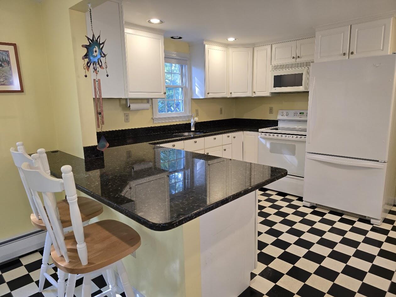 15 Woodside Park Road West Dennis, MA 02670 - Photo 5 of 35 a kitchen with stainless steel appliances granite countertop a sink a stove a microwave a refrigerator and white cabinets