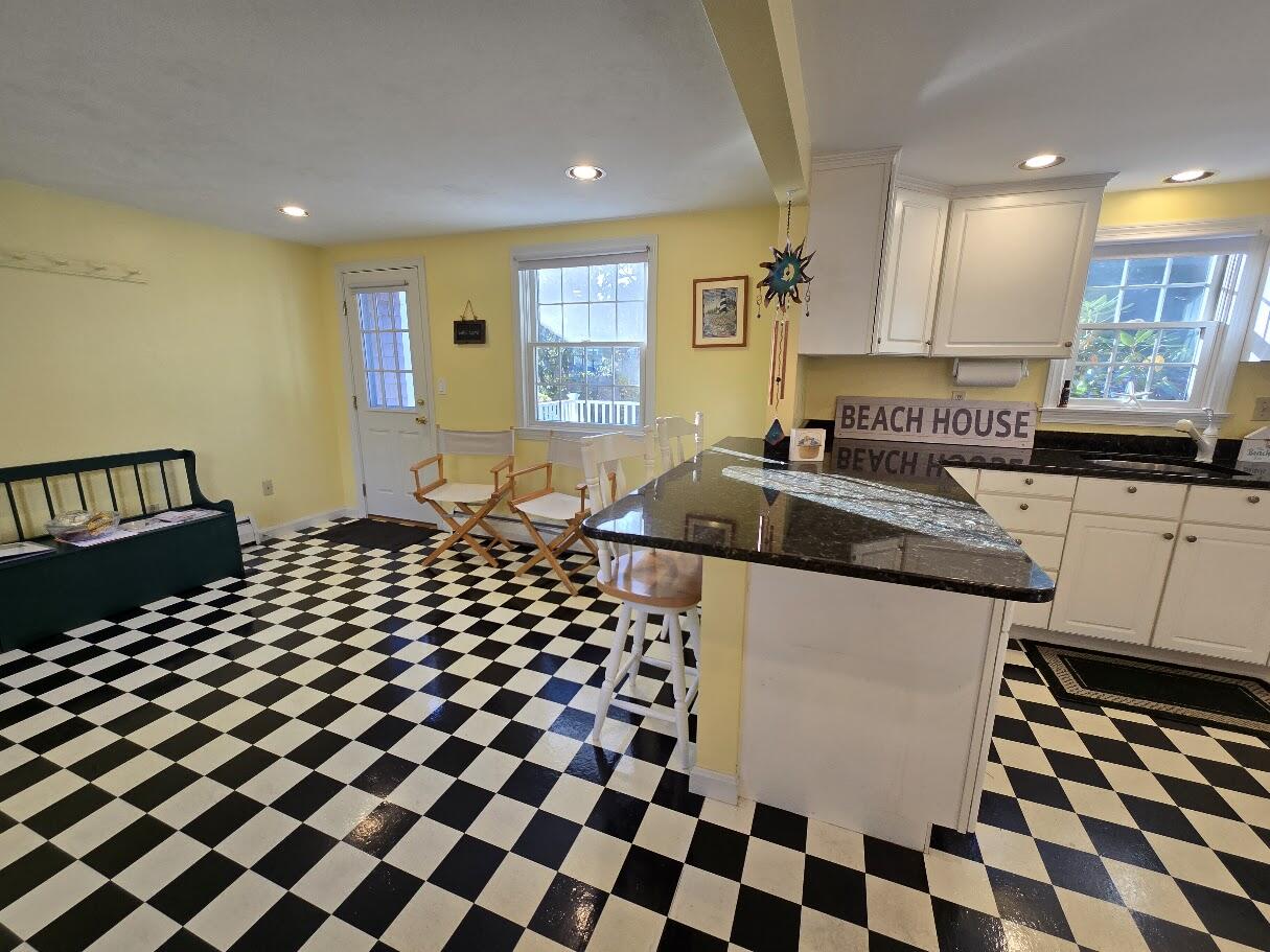 15 Woodside Park Road West Dennis, MA 02670 - Photo 7 of 35 a kitchen with a checkered floor and white cabinets