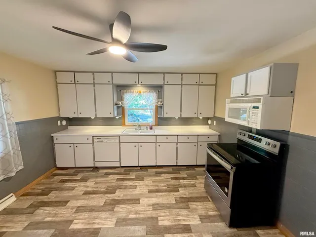 a kitchen with a stove sink and cabinets