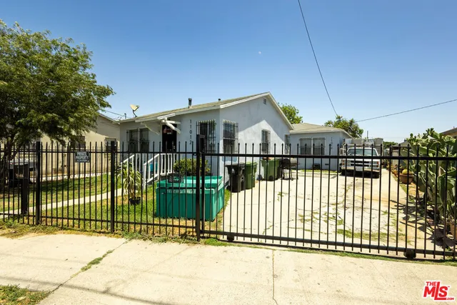 a view of a house with a small yard and wooden fence
