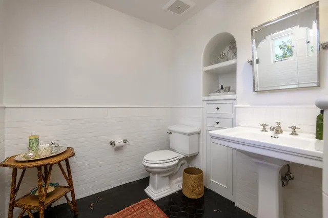 a bathroom with a toilet sink and mirror