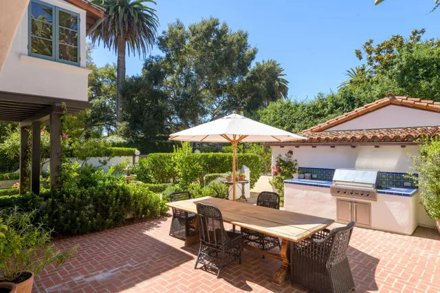a patio with a table and chairs under an umbrella