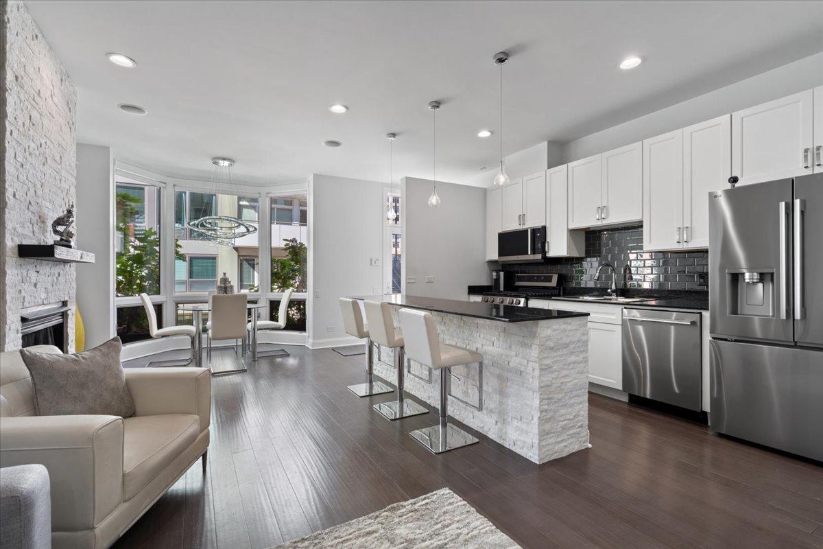 641 West Wayman Street, Unit B Chicago, IL 60661 - Photo 8 of 25 a kitchen with stainless steel appliances granite countertop a refrigerator a stove top oven a sink dishwasher and white cabinets with wooden floor