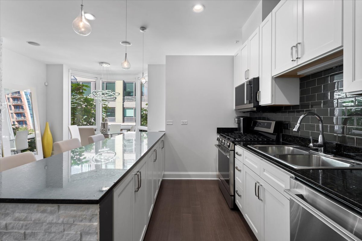 641 West Wayman Street, Unit B Chicago, IL 60661 - Photo 10 of 25 a kitchen with stainless steel appliances granite countertop a sink a stove and a refrigerator