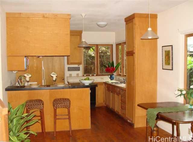 a kitchen with a sink a refrigerator and wooden floor