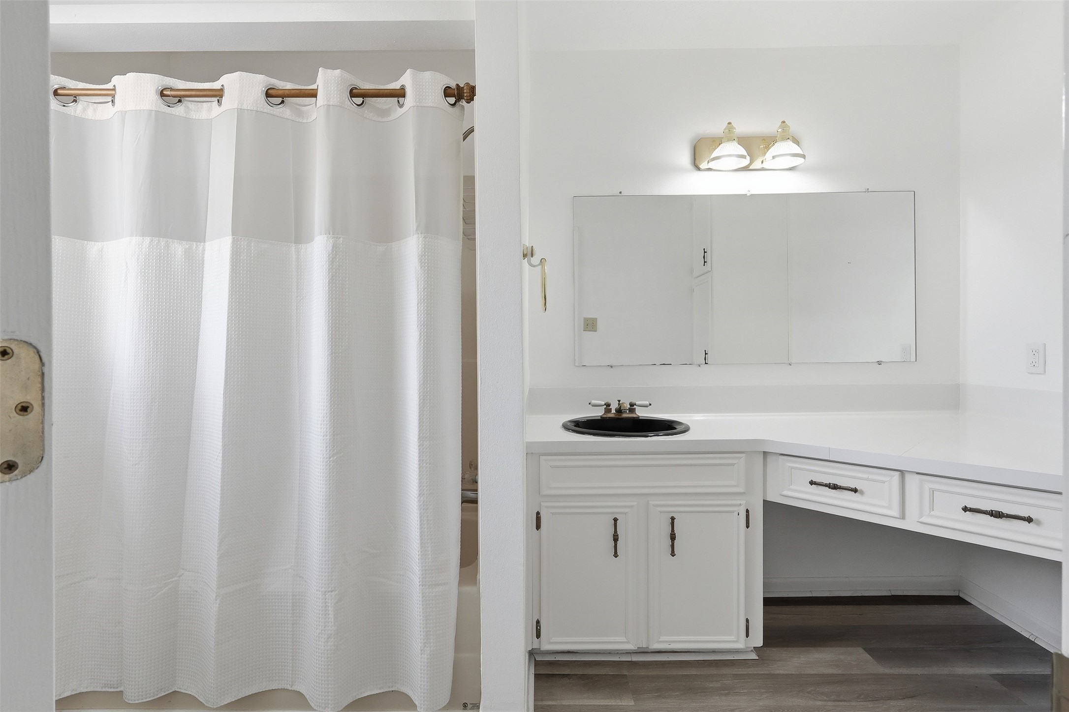 614 Tallow Drive Conroe, TX 77385 - Photo 27 of 36 Upstairs bathroom with a white shower curtain, spacious vanity, large mirror, and dual overhead lights. Features sleek black sink and ample cabinet storage.